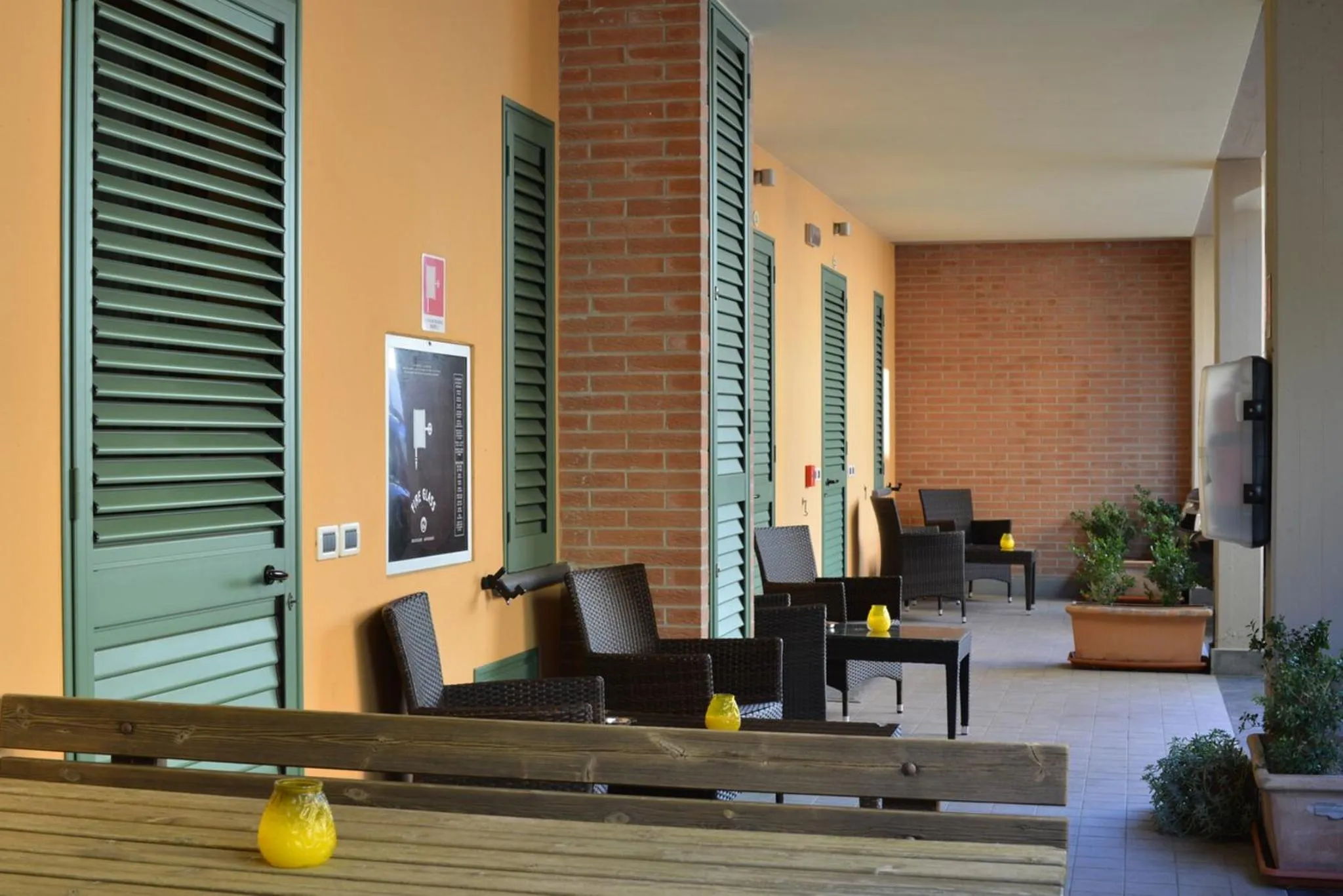 Terrasse ombragée avec mobilier de jardin et plantes en pots.