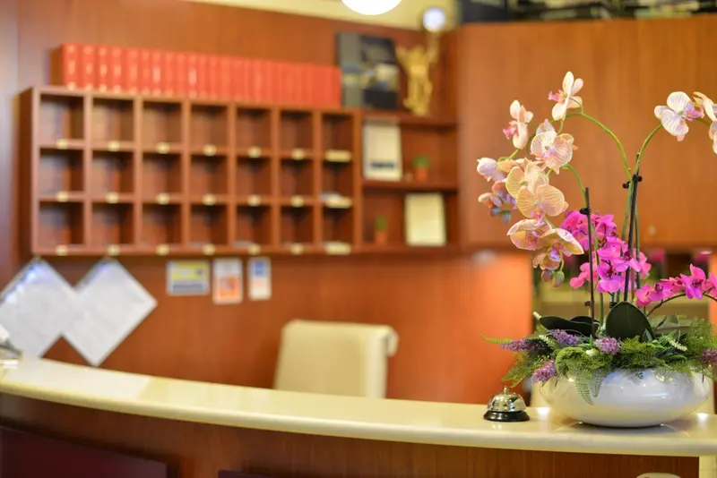 Un comptoir d'accueil en bois orné de fleurs et de documents.