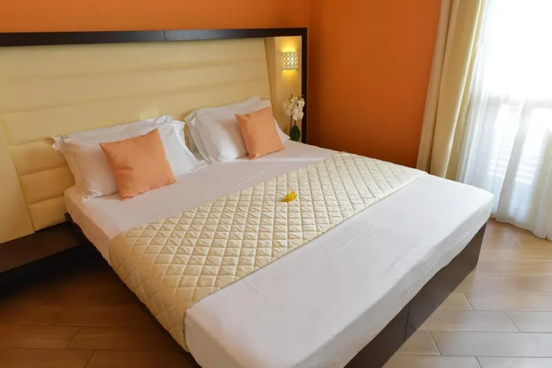 Une chambre lumineuse avec un grand lit recouvert d'une courtepointe.