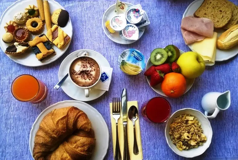 Un plateau de petit-déjeuner avec viennoiseries, fruits et boissons.