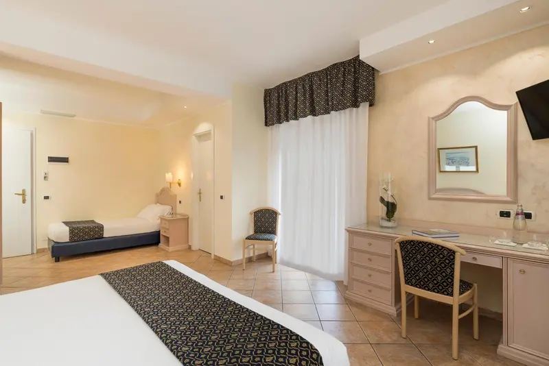 Chambre lumineuse avec un lit double et un bureau en bois.
