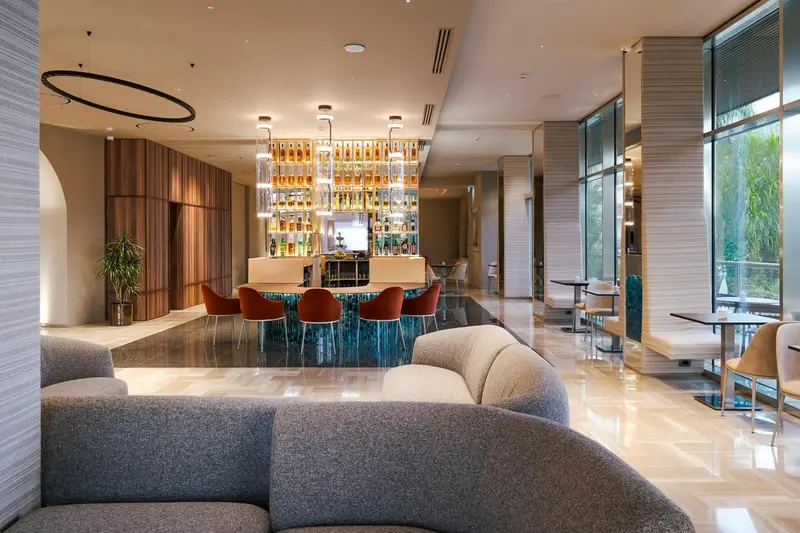 Un espace de détente avec canapés et un bar lumineux.
