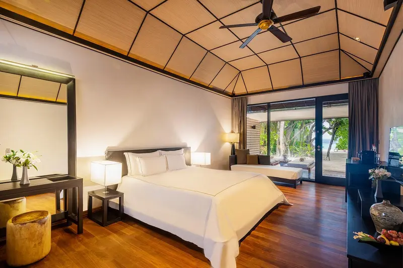 Une chambre lumineuse avec un grand lit et un accès à une terrasse.