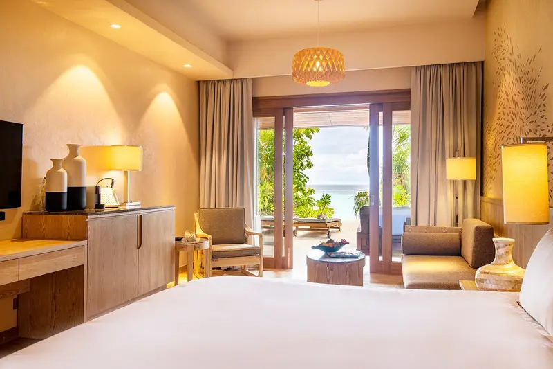 Une chambre lumineuse s'ouvre sur une terrasse avec vue sur la mer.