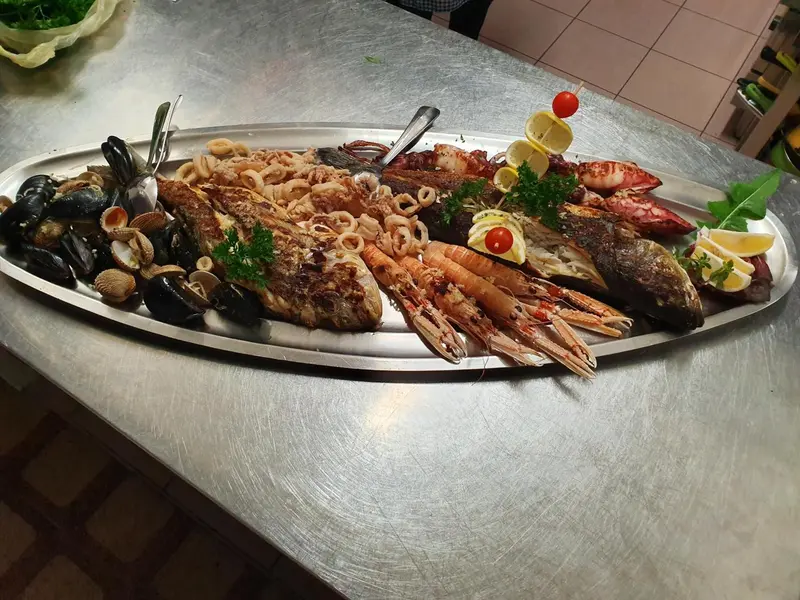 Un grand plateau de fruits de mer est présenté sur un comptoir en acier inoxydable.