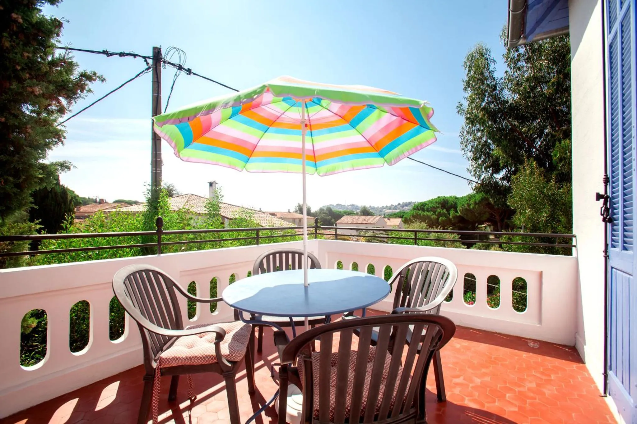 Terrasse ombragée avec table et chaises en osier.