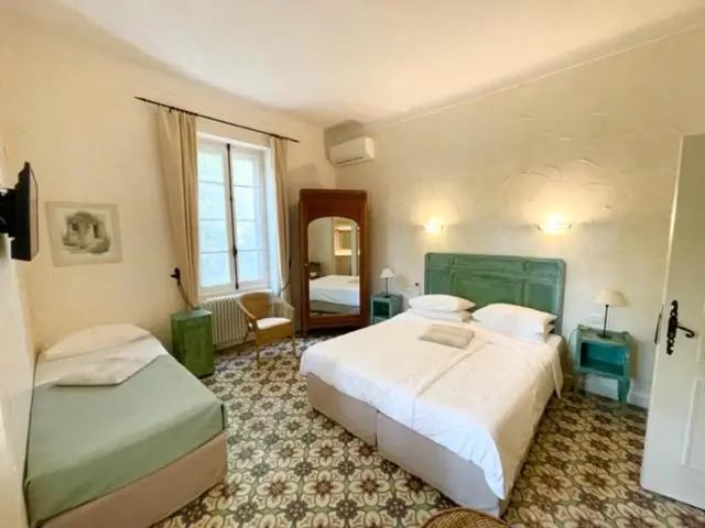 Une chambre lumineuse avec deux lits et un miroir.