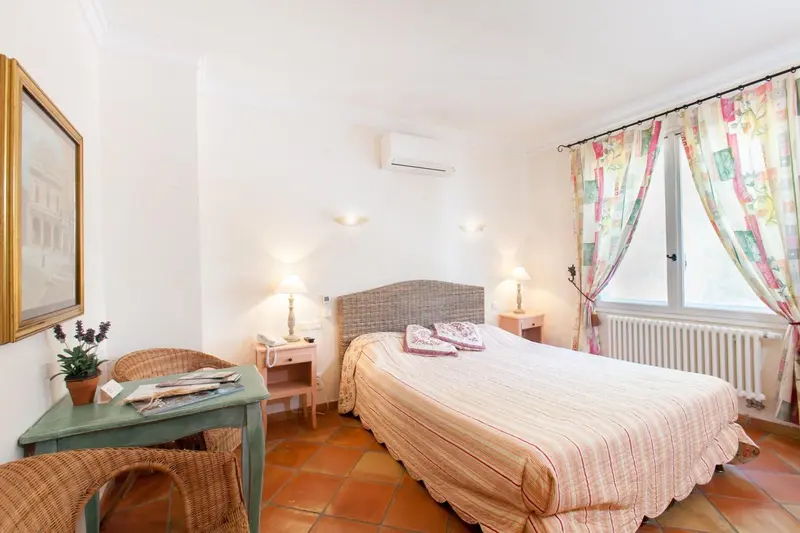 Une chambre lumineuse avec un lit double et une décoration florale.