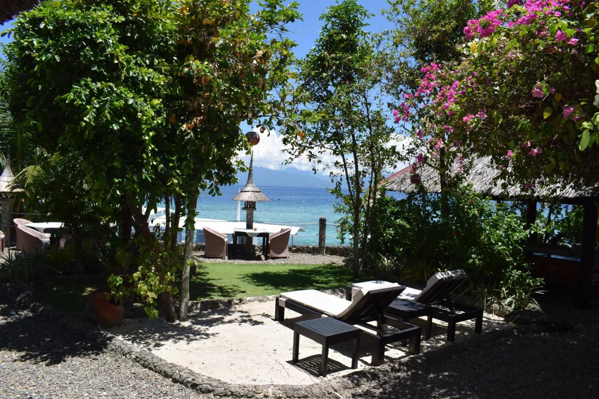 Espace extérieur aménagé avec des transats et une vue sur la mer.