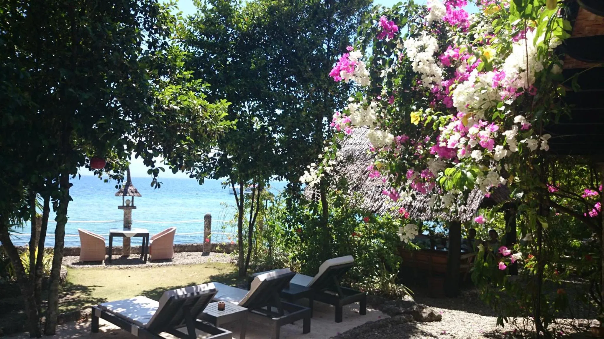 Transats et mobilier de jardin face à la mer.