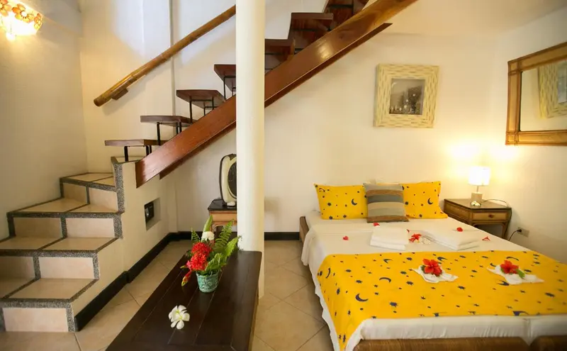 Une chambre lumineuse avec un escalier menant à l'étage.