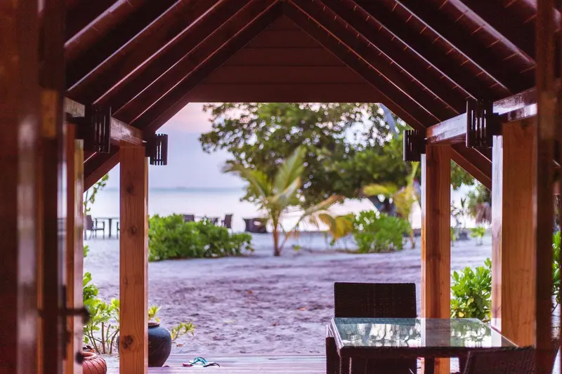 Une terrasse en bois offre une vue sur la plage et la mer.