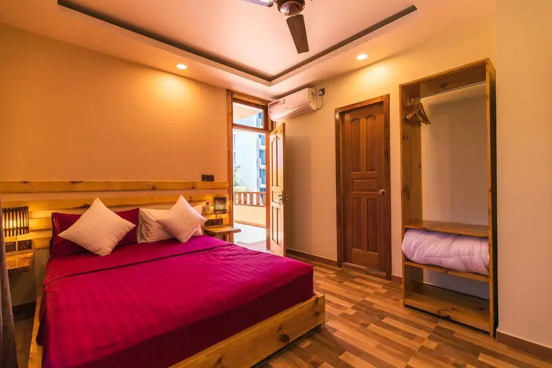 Une chambre à coucher lumineuse avec un lit à baldaquin et un placard en bois.