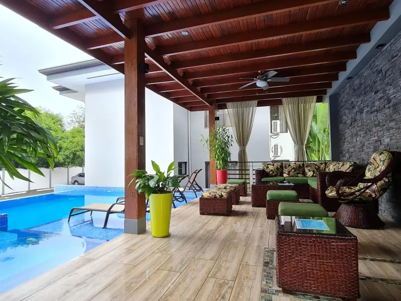 Espace de détente extérieur avec piscine et mobilier de jardin.