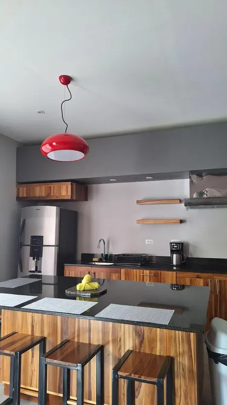 Une cuisine moderne avec un îlot central en bois et des tabourets.