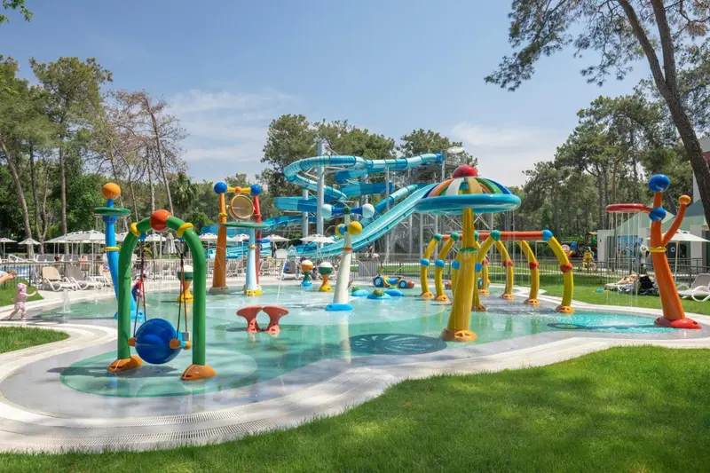 Un parc aquatique coloré avec des toboggans et des jeux d'eau pour enfants.