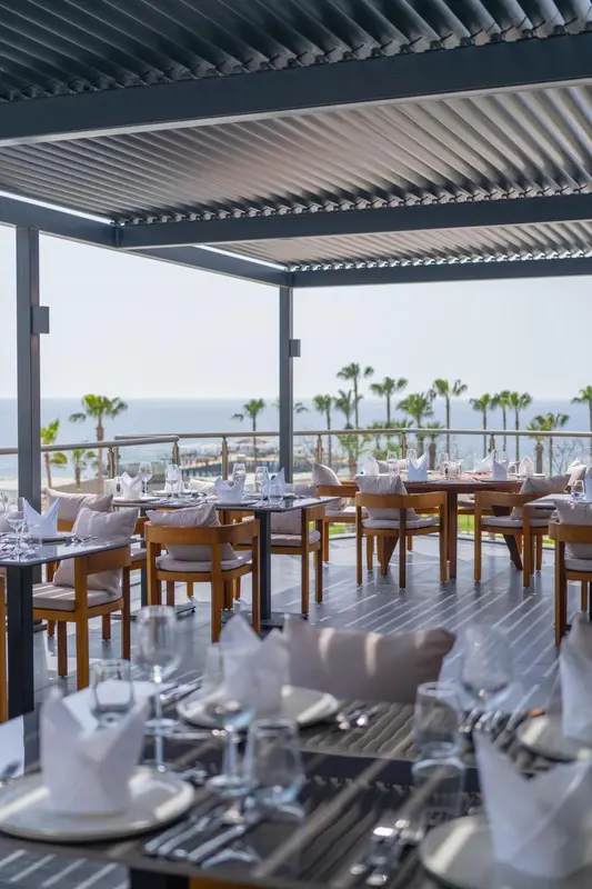Tables dressées en extérieur avec vue sur la mer.