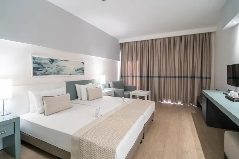 Une chambre lumineuse avec un grand lit et un coin salon.