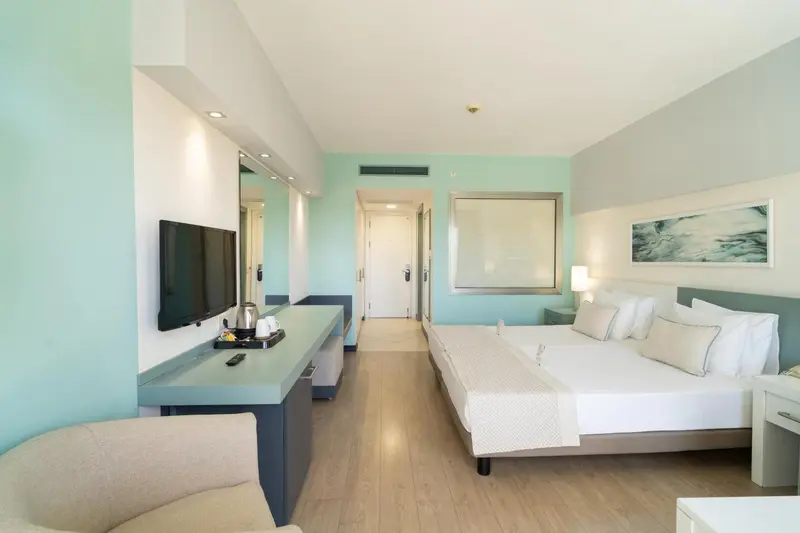 Chambre lumineuse avec un grand lit et un espace détente.