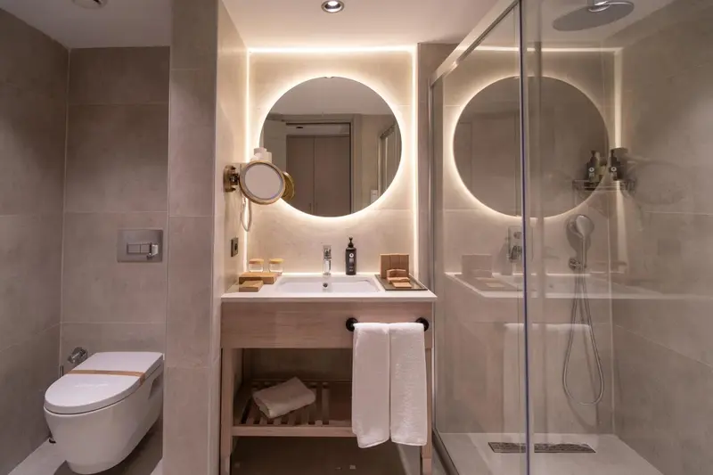 Une salle de bain moderne avec douche à l'italienne et grand miroir.