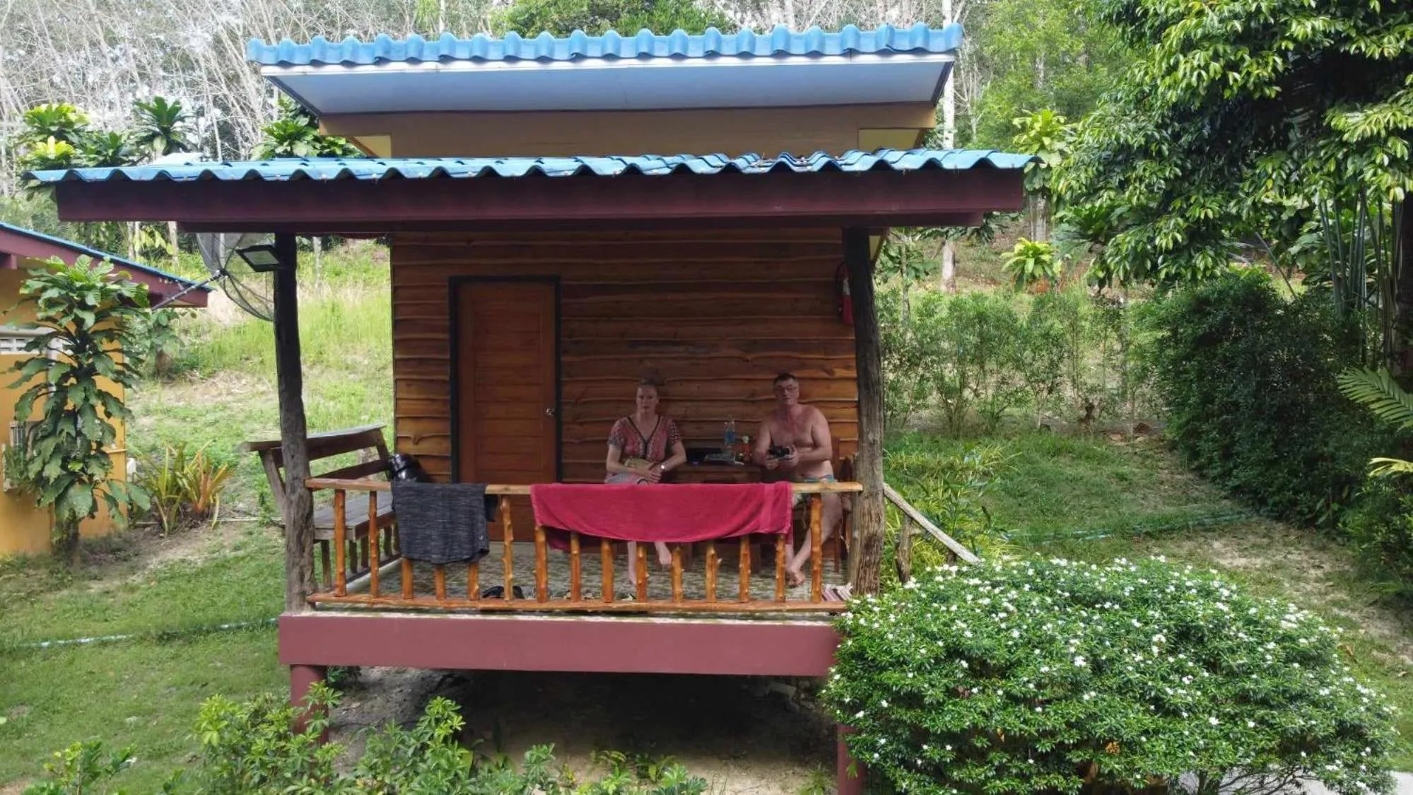 Deux personnes sont assises sur la terrasse d'une cabane en bois.
