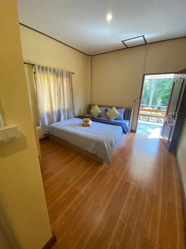 Une chambre lumineuse avec un grand lit et un accès à une terrasse.