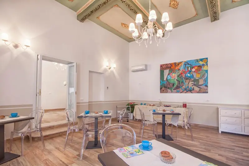 Une salle lumineuse avec des tables et des chaises pour le petit-déjeuner.