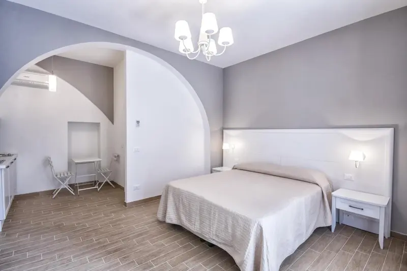 Une chambre lumineuse avec un lit double et un coin repas.