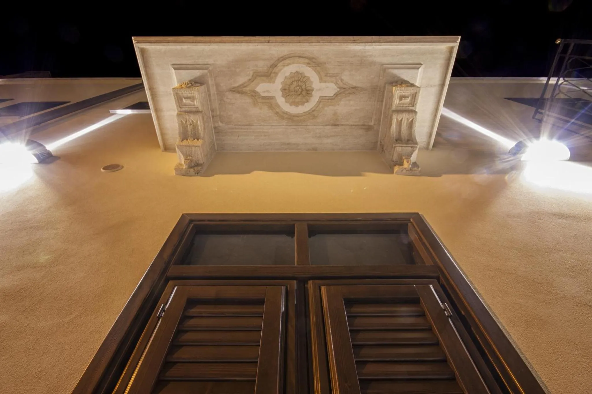 Ouverture décorative au-dessus d'une entrée sombre.
