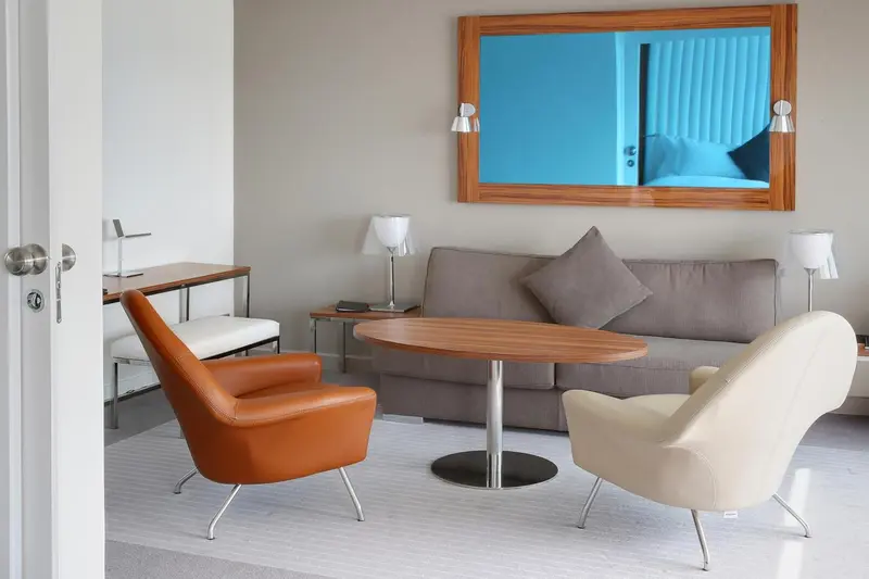 Un salon moderne avec canapé, fauteuils et table basse.