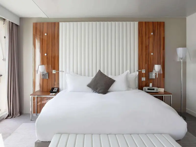 Un lit blanc est dispose dans une chambre moderne et lumineuse.