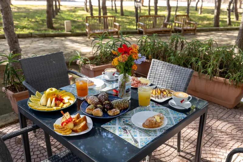 Une table est dressée avec des pâtisseries, des fruits et des boissons.