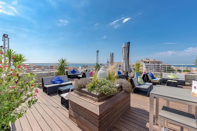 Terrasse aménagée avec mobilier de détente et vue sur la mer.