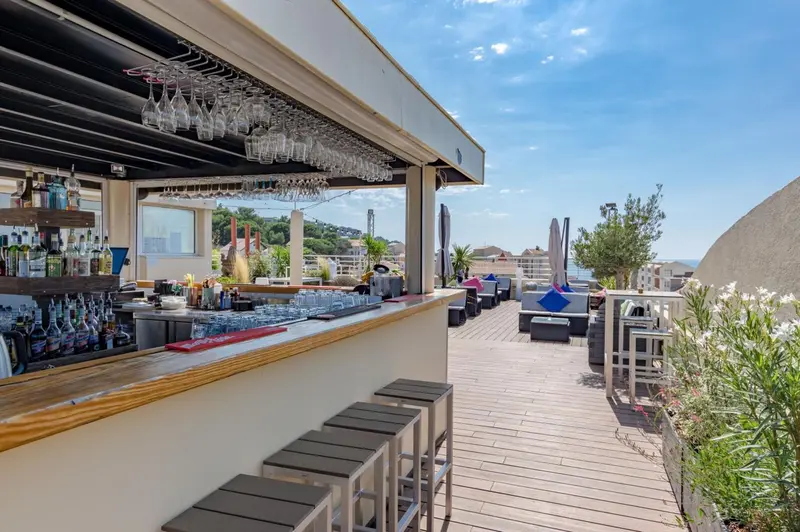 Un bar en plein air offre une vue sur la mer et la ville.