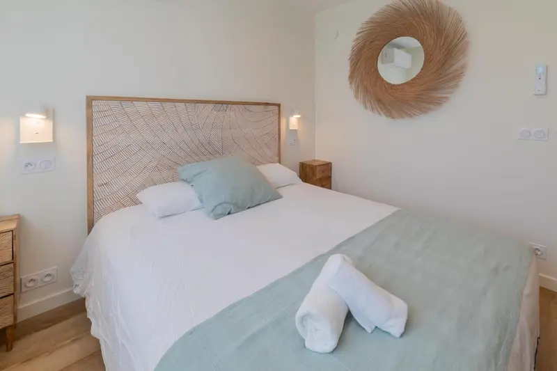 Une chambre lumineuse avec un grand lit et une décoration naturelle.
