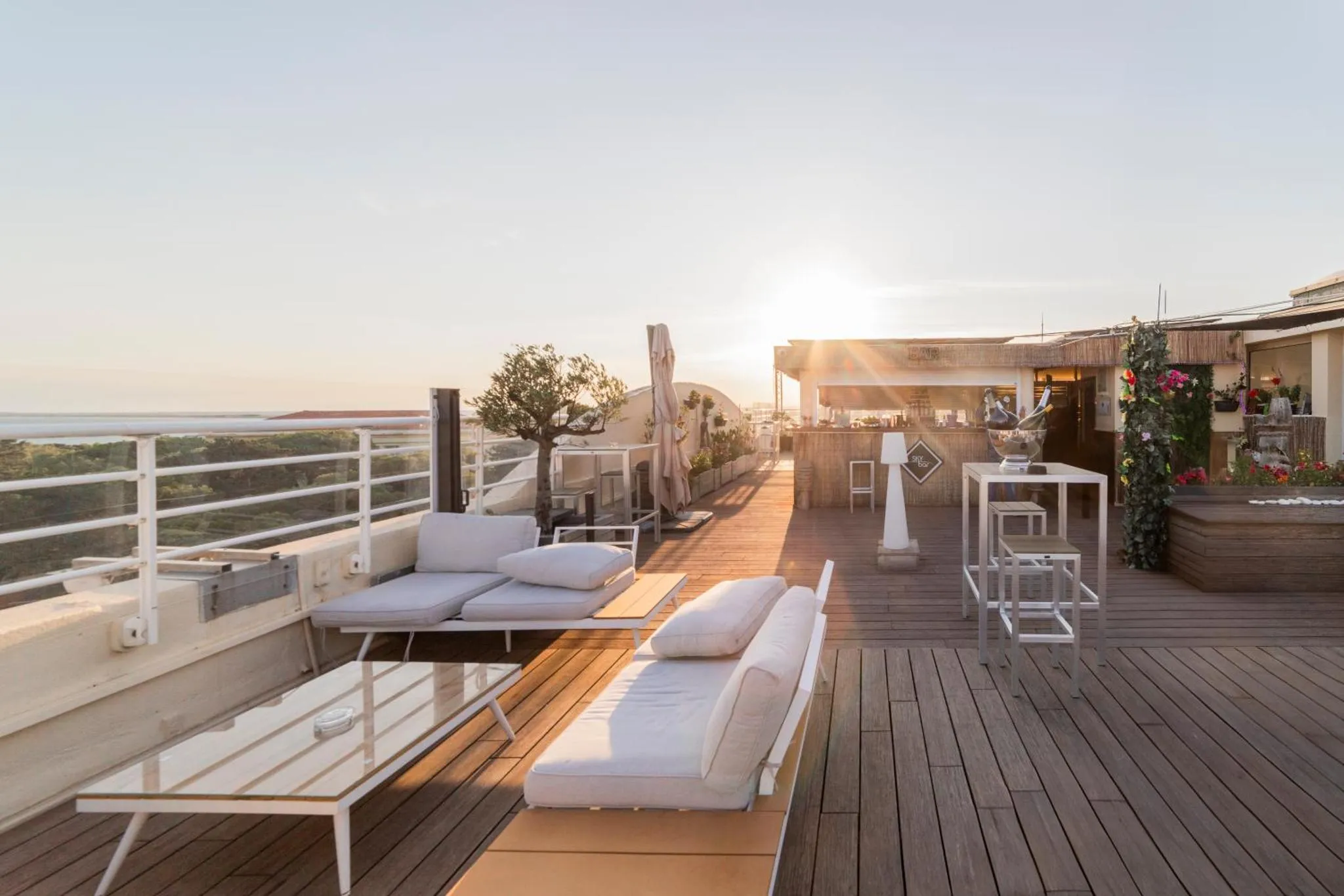 Terrasse aménagée avec des transats et des tables basses, offrant une vue sur la mer.
