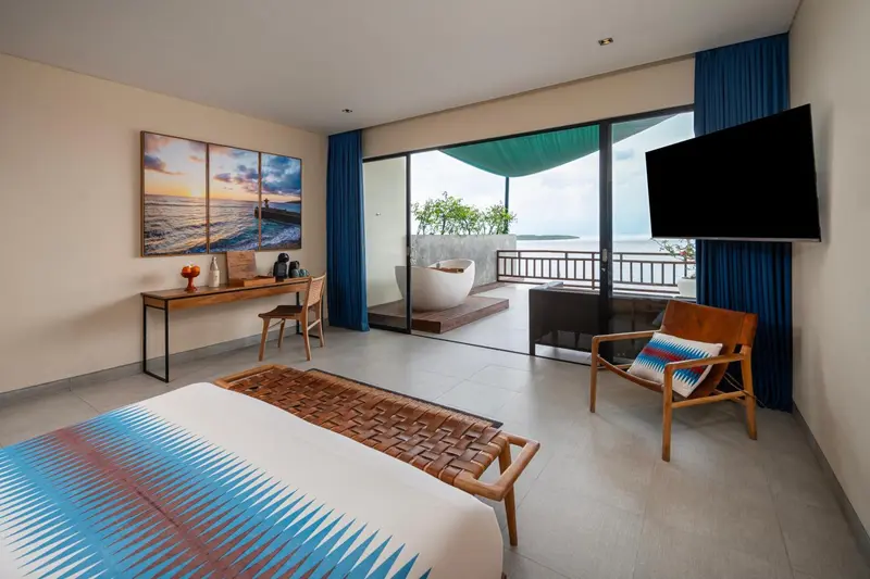 Une chambre lumineuse avec un grand lit et un accès à une terrasse avec baignoire.