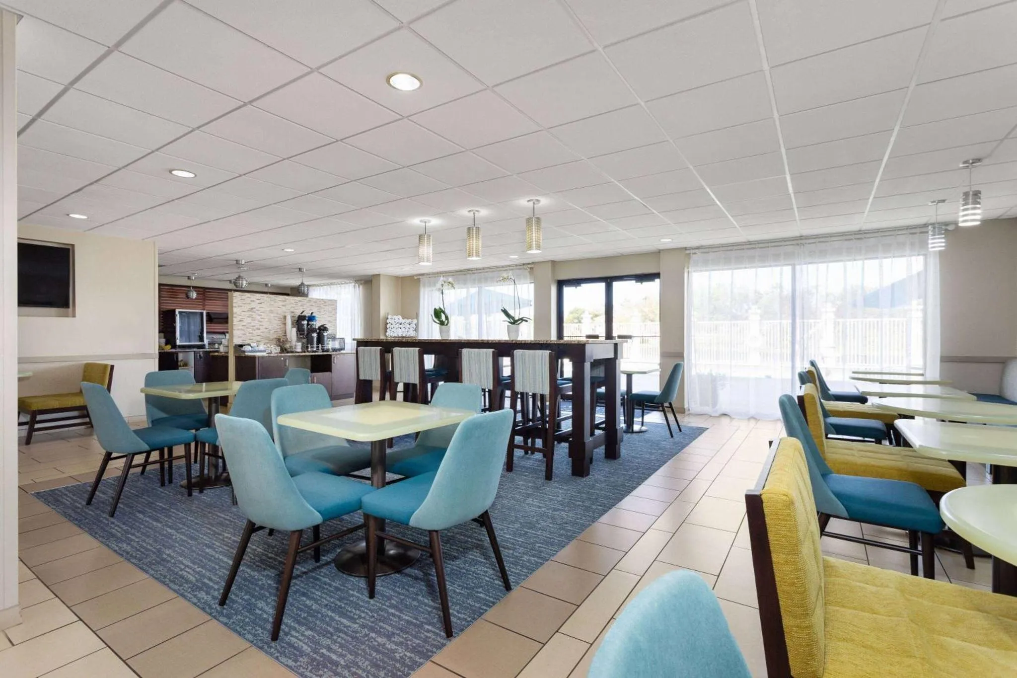 Une salle lumineuse avec des tables et des chaises pour le petit-déjeuner.
