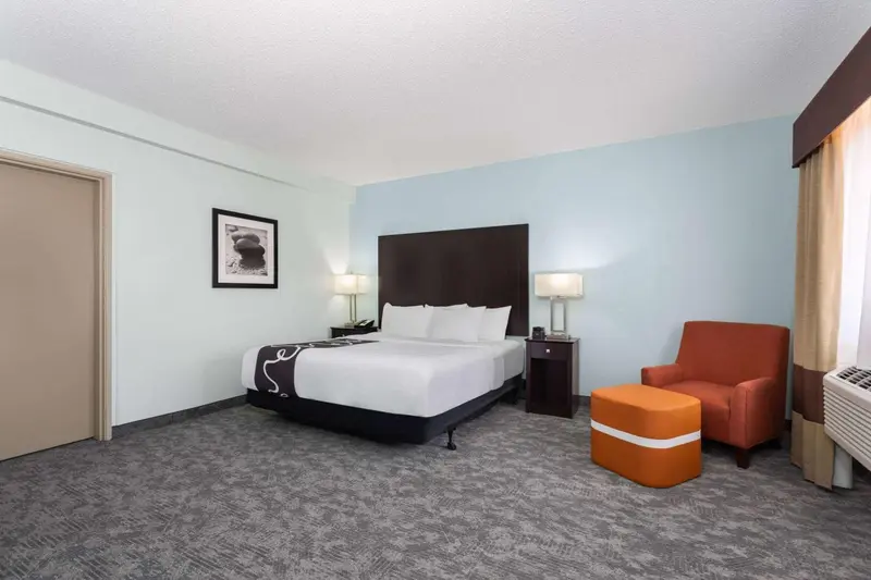 Une chambre d'hôtel avec un lit double et un fauteuil.