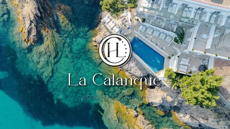 Vue aérienne d'un hôtel avec piscine et accès à la mer turquoise.