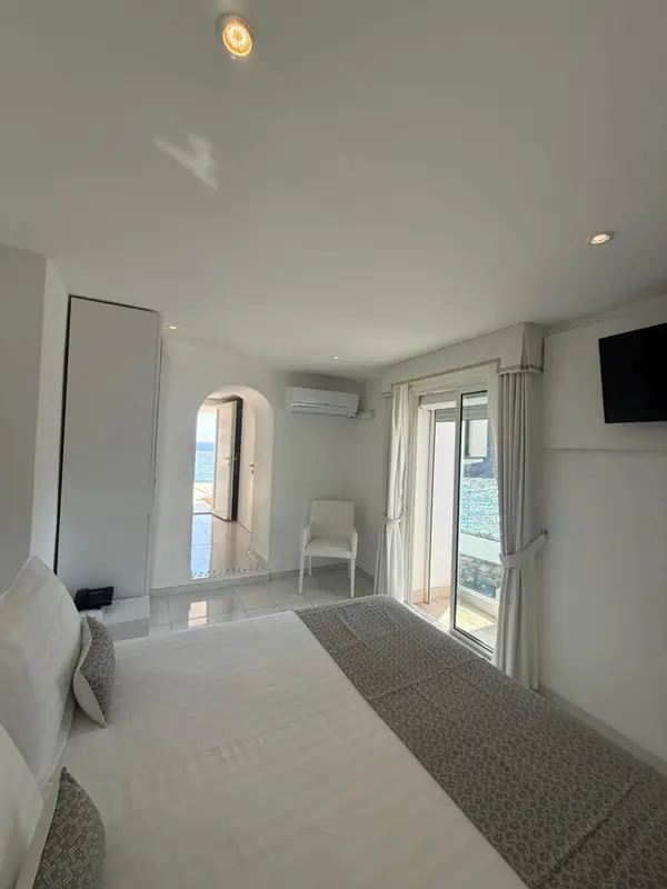 Une chambre lumineuse avec un lit et un accès à une terrasse.