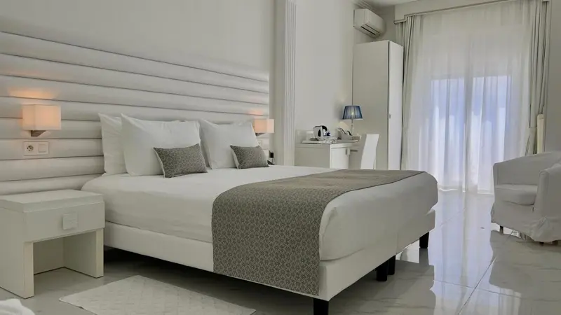 Une chambre lumineuse avec un grand lit et un coin salon.