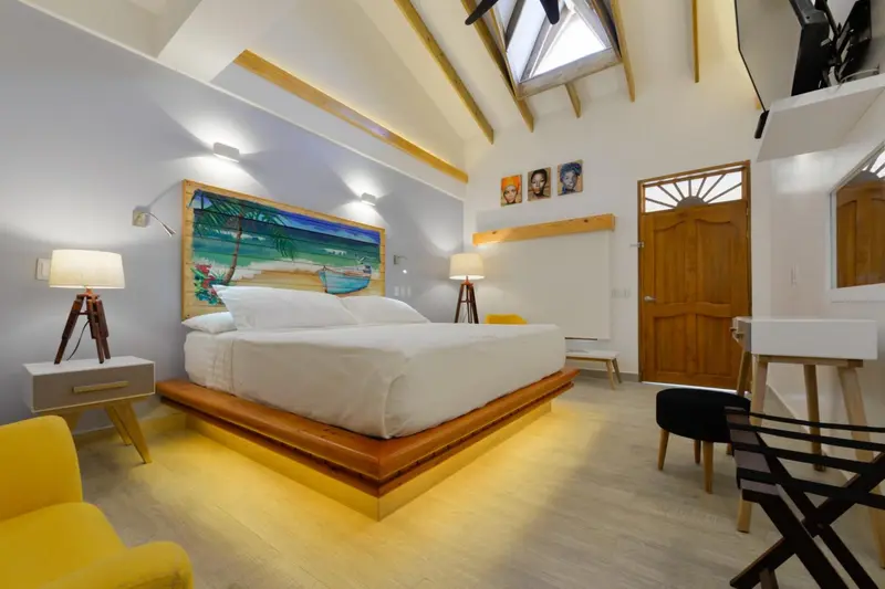 Une chambre lumineuse avec un grand lit et une décoration colorée.