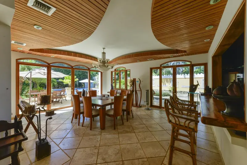 Une salle à manger lumineuse s'ouvre sur une terrasse avec vue sur une piscine.
