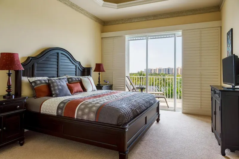 Une chambre avec un grand lit et un accès à une terrasse.