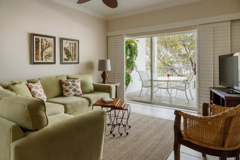 Un salon clair s'ouvre sur une terrasse avec mobilier d'extérieur.