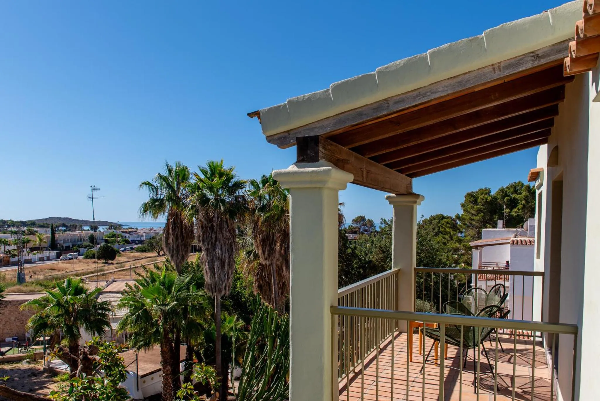 Terrasse ombragée donnant sur une vue dégagée sur la mer et la végétation.