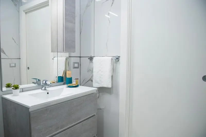 Une salle de bain moderne avec un lavabo blanc et des carreaux gris.