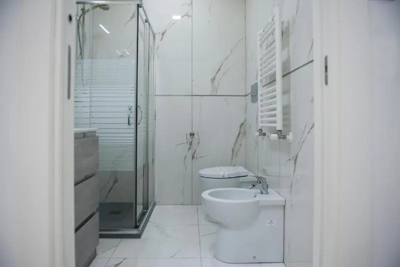 Une salle de bain moderne avec douche à l'italienne et sanitaires blancs.