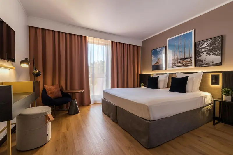 Une chambre d'hôtel lumineuse avec un grand lit et un coin salon.